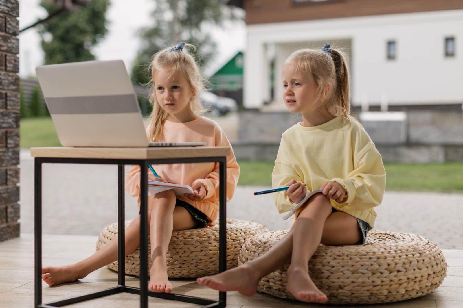 Two young children working at a laptop together