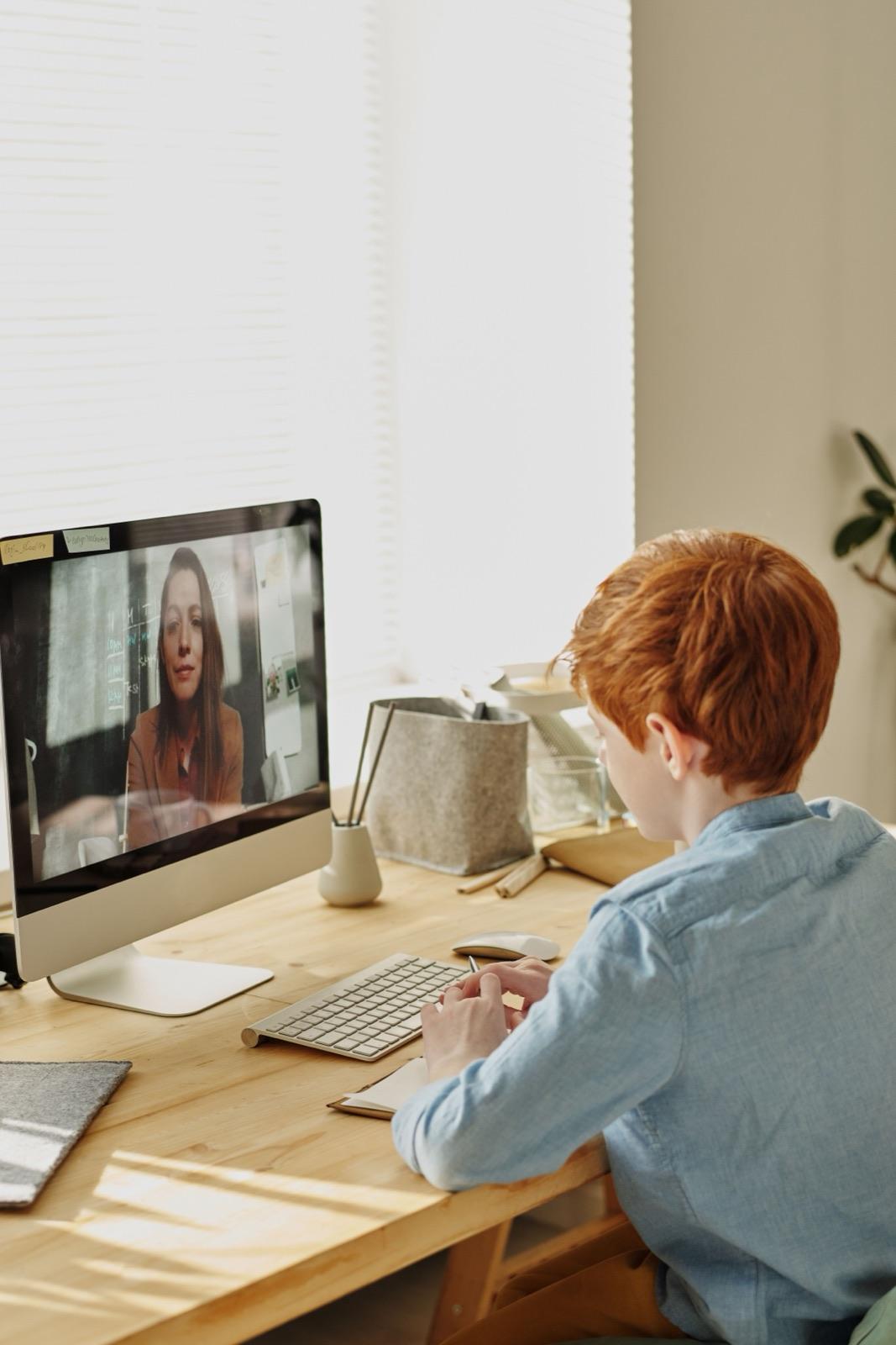 A teenager in a focused one-to-one session at a desktop computer
