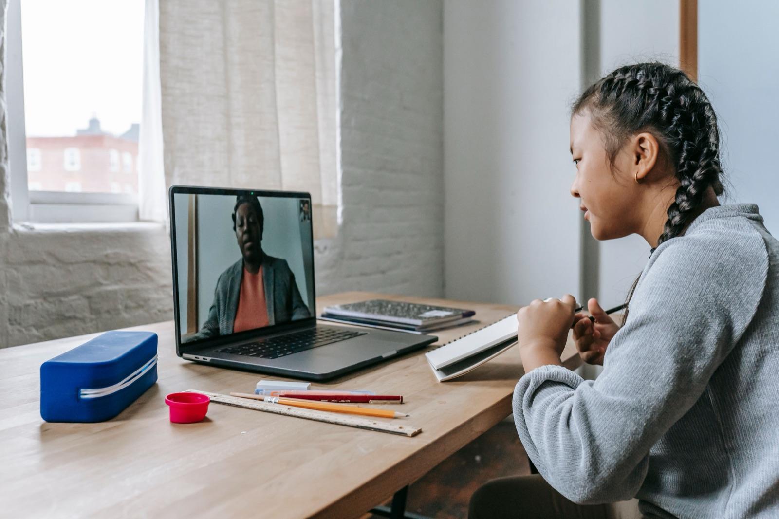 A teenager in a live one-to-one online lesson, the tutor on screen
