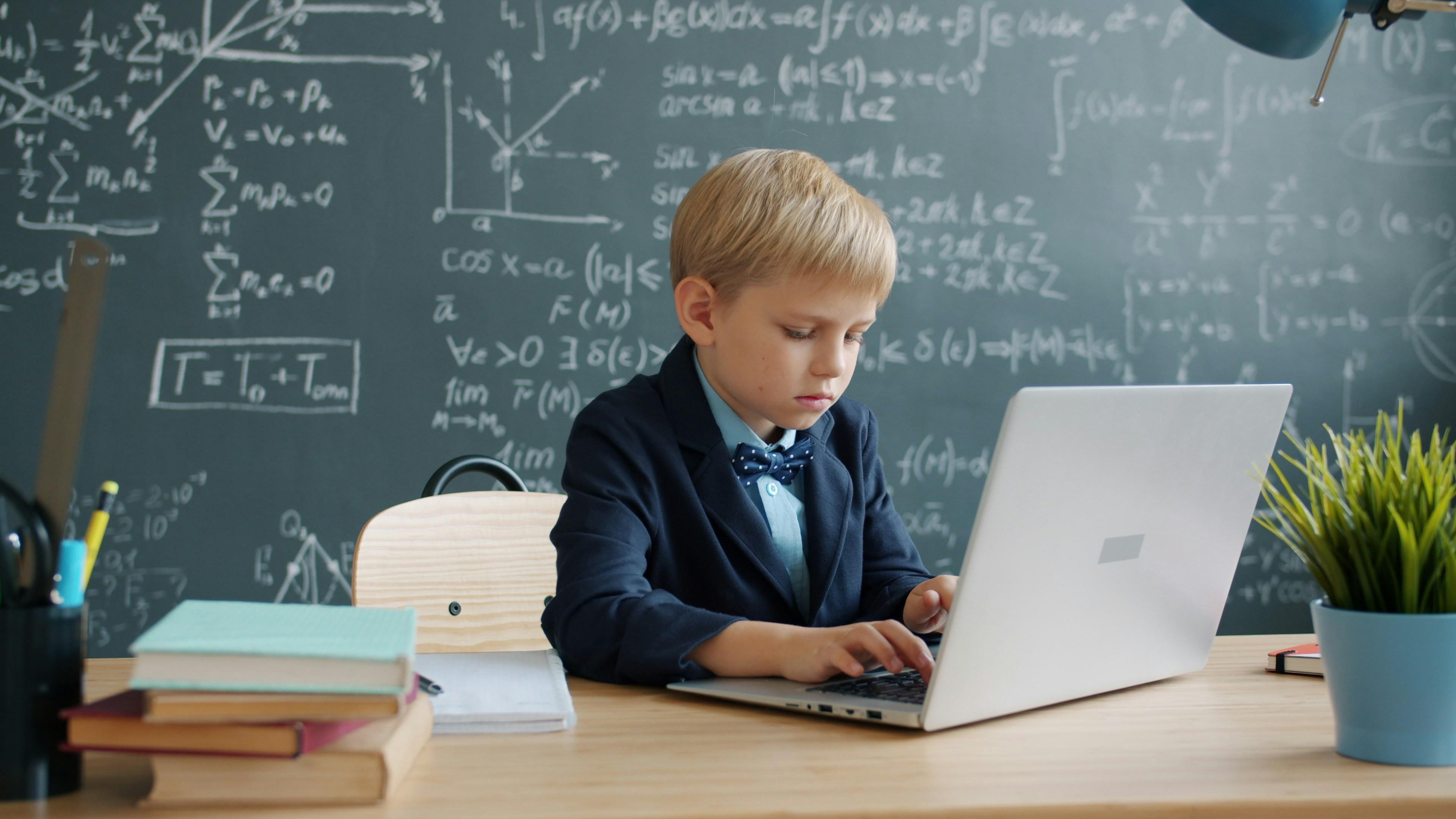 A child taking an online class on a laptop at a desk